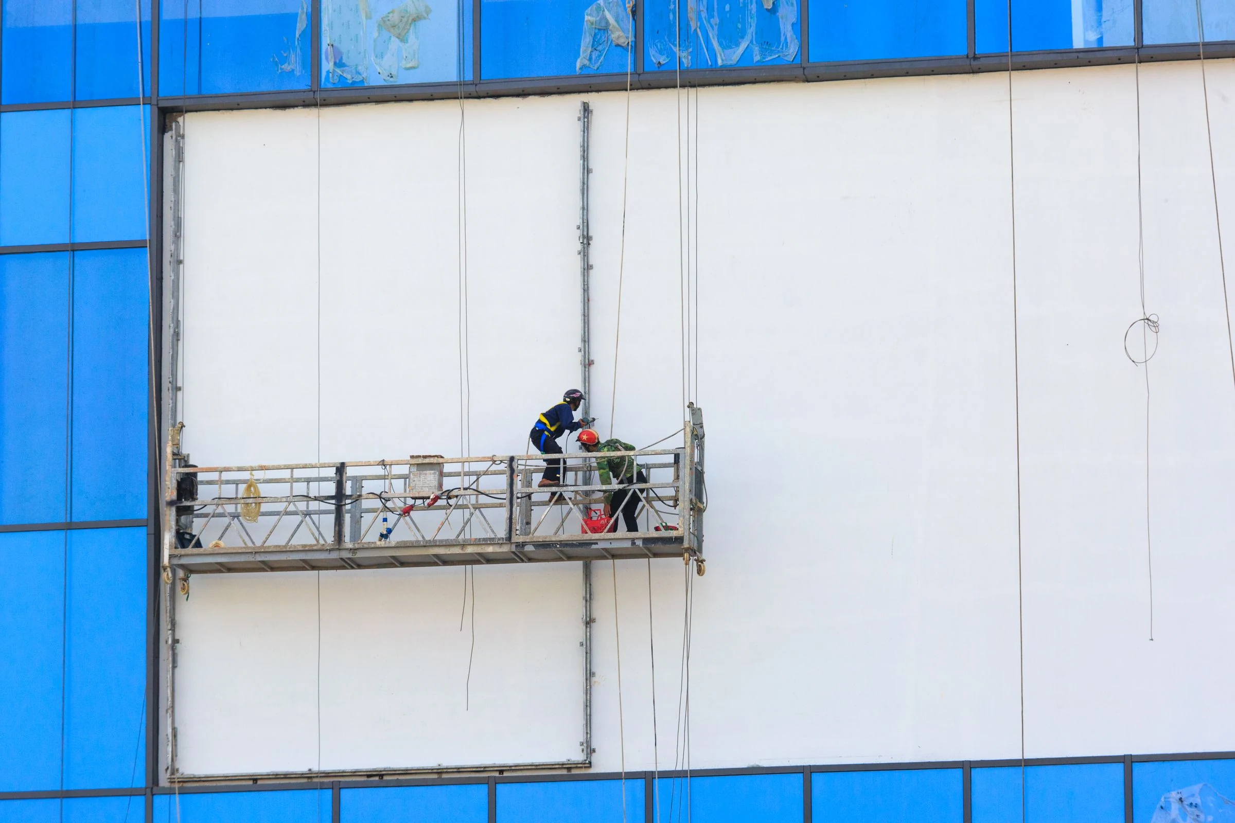 Technicians maintaining a building facade